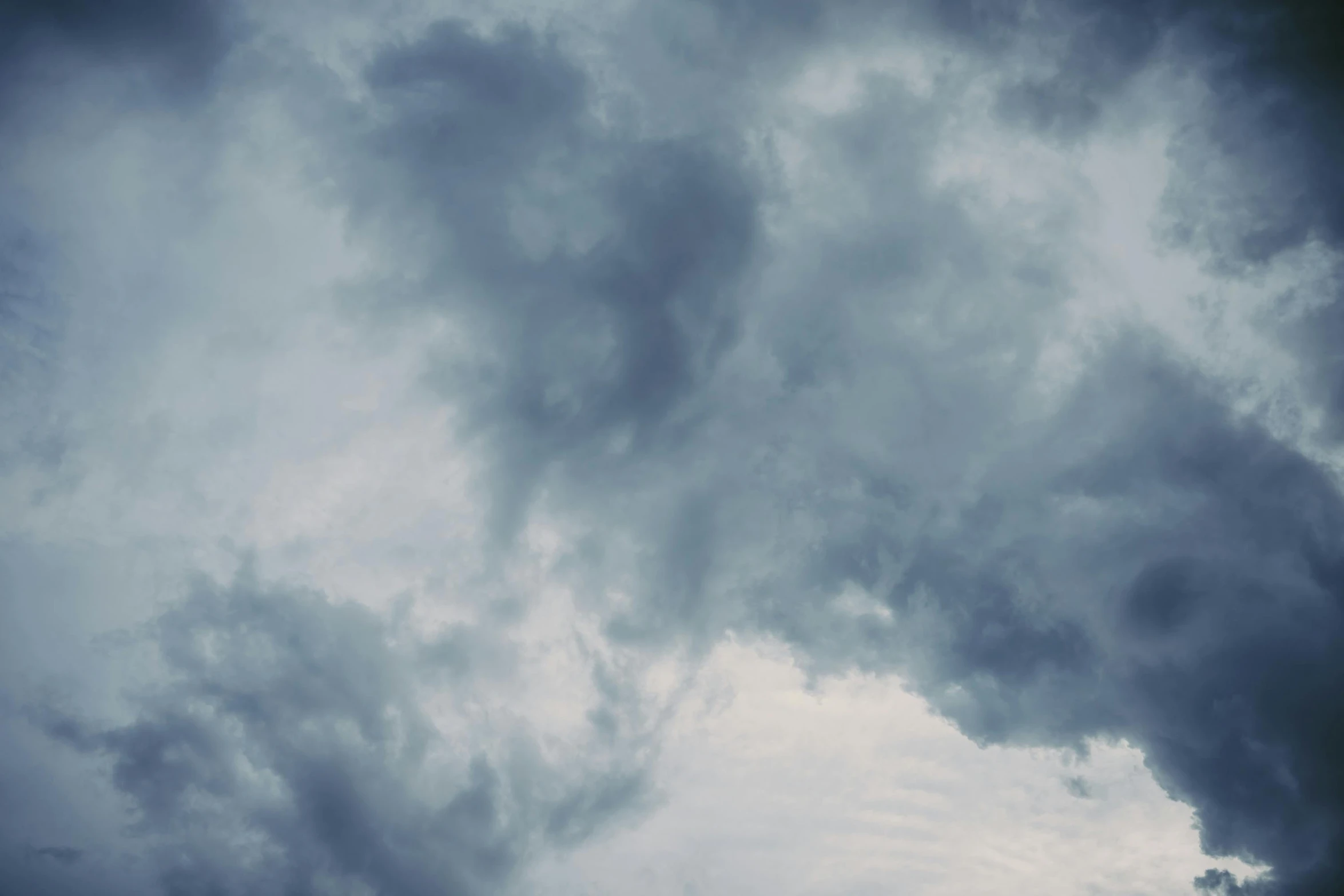 a black cloud is in the sky with an airplane