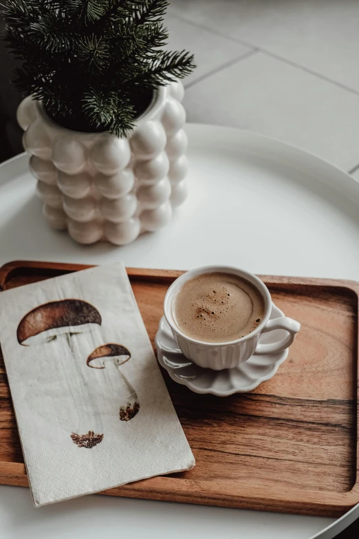 a coffee cup with a painting on top of a tray