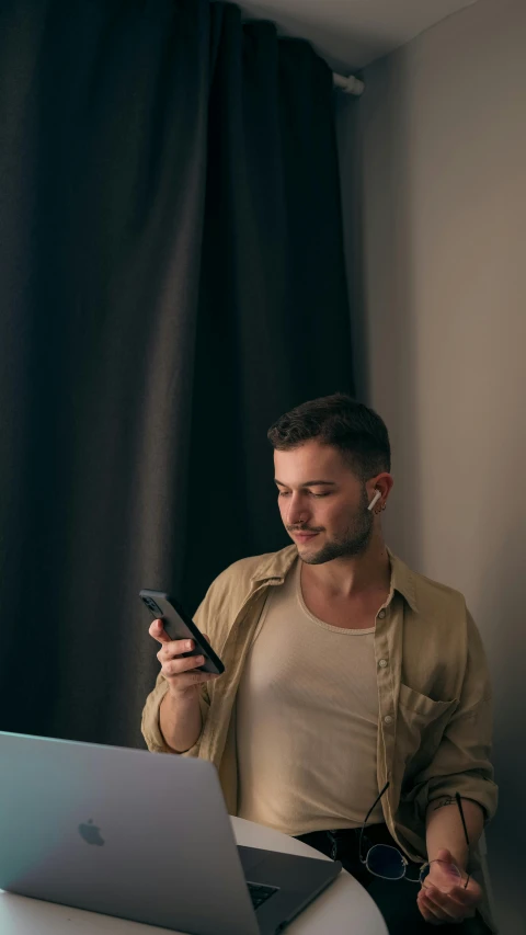 a man with headphones holding a smart phone