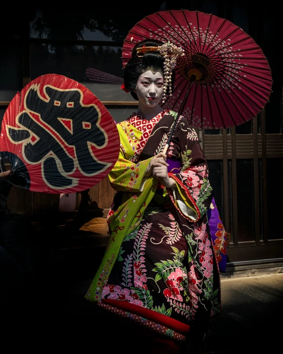 a lady wearing a traditional costume carrying an umbrella