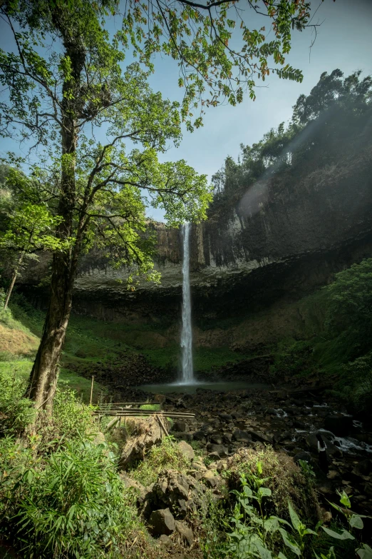 a large waterfall is shown in the distance on a sunny day