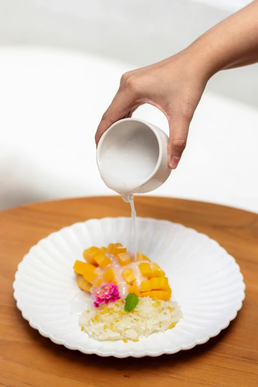 someone pours liquid into a paper plate with fruit