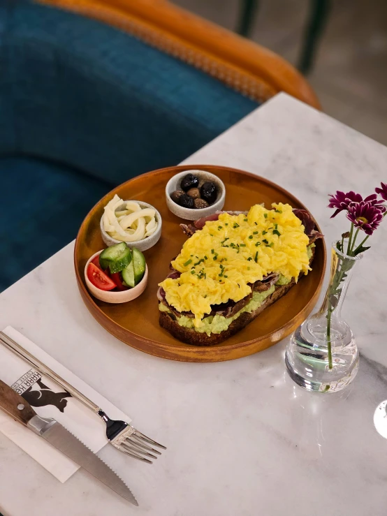 a plate with scrambled eggs and small pickles