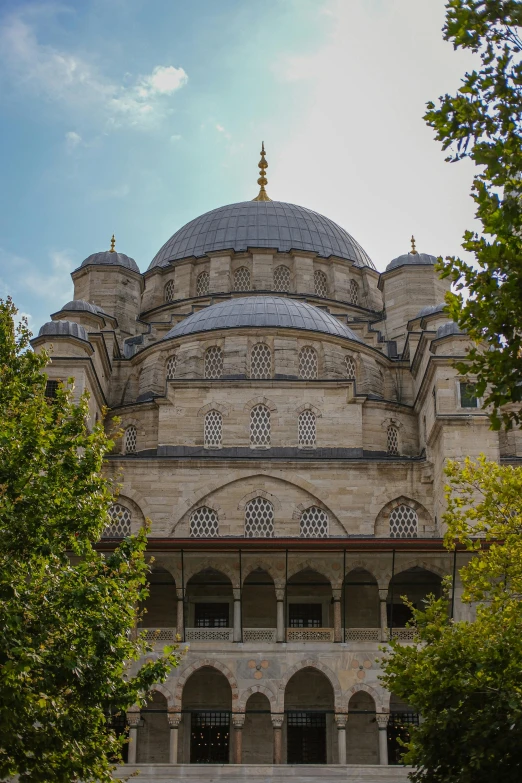 a large building sitting next to trees with its roof open