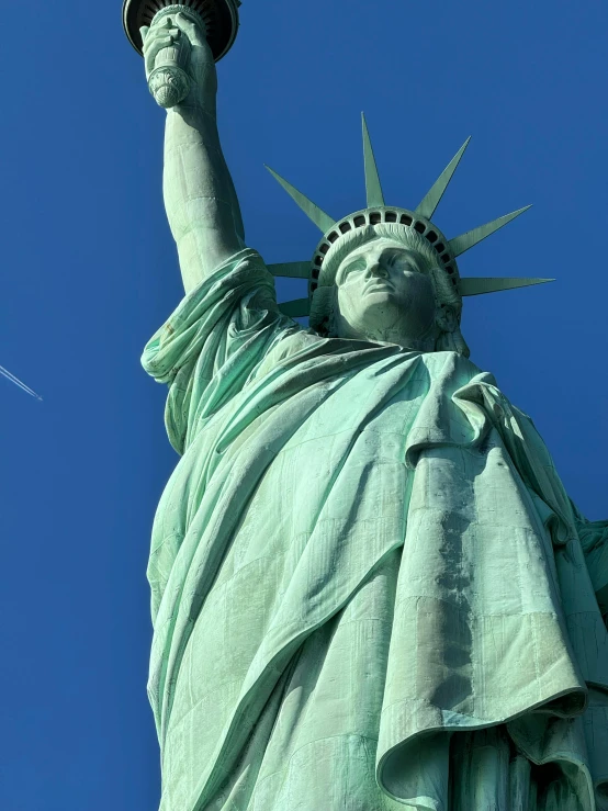 the statue of liberty with an american flag on top