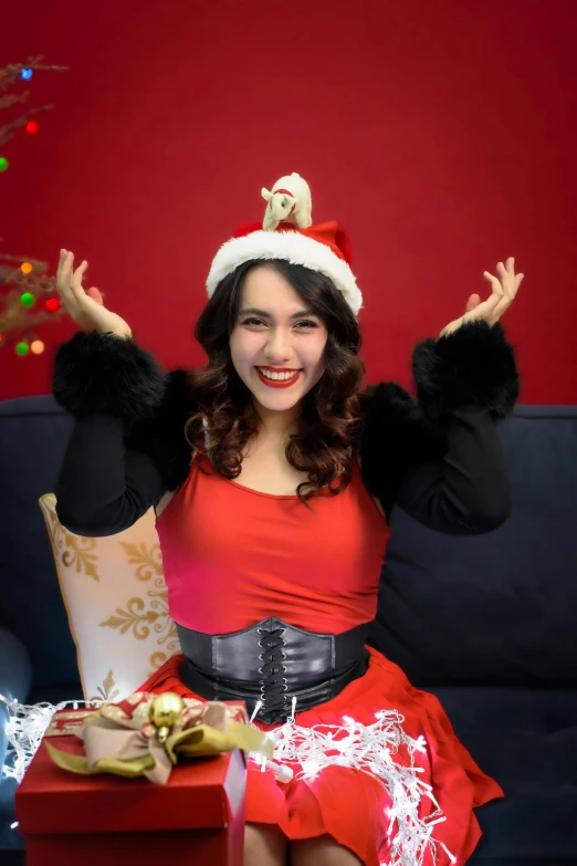 a woman in a santa hat is holding her arms up