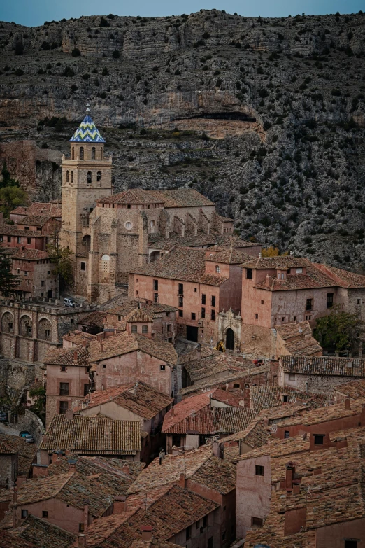 a po of a city below mountains with a clock tower