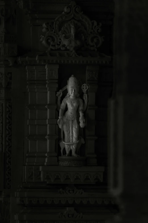 statue of a man is standing in front of a wall