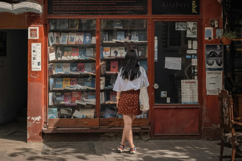 a  standing outside a book shop looking at a window