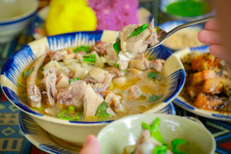 a couple bowls of soup sitting on a table with other foods