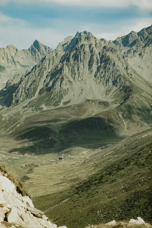 a lone backpacker overlooking a mountain valley and its many majestic peaks