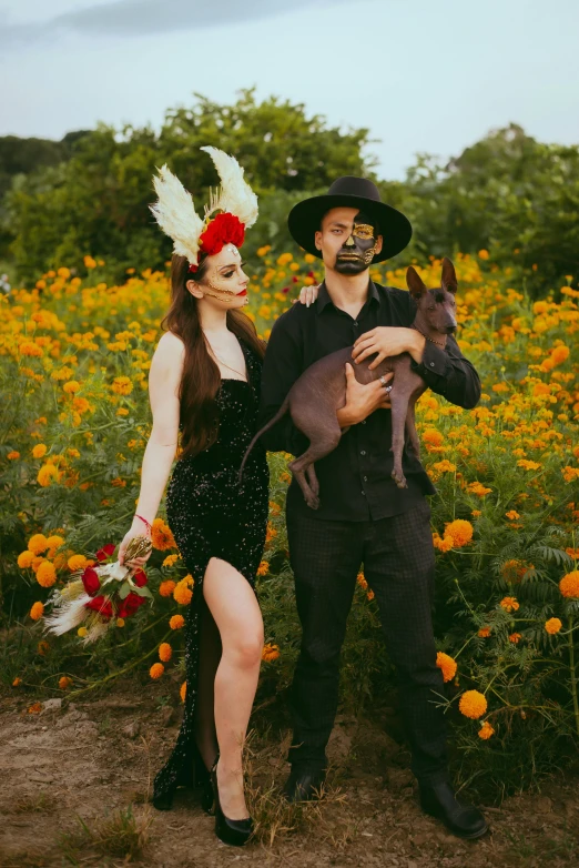 a man and woman standing in a field with a dog