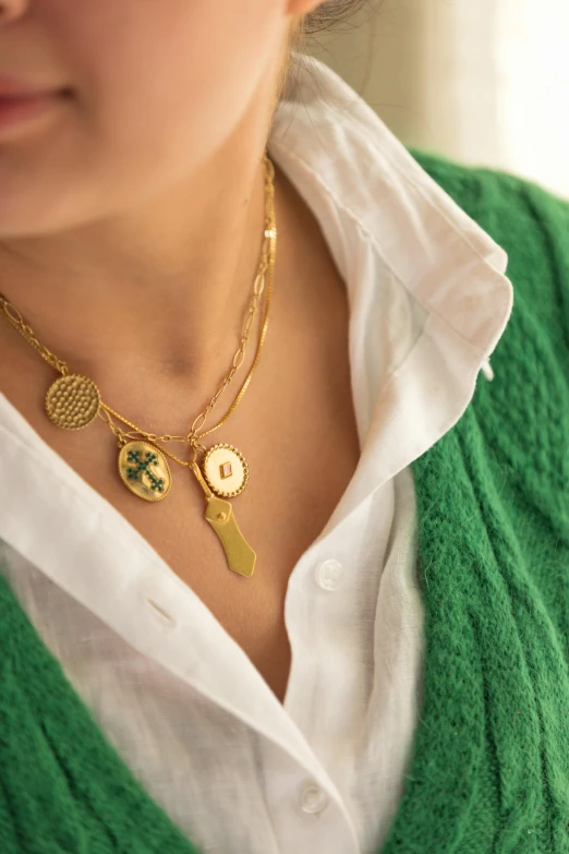 a young lady with a green sweater has a key necklace