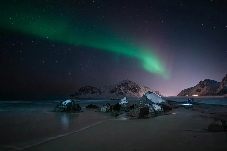 a couple of rocks in the snow with the lights on and some green and yellow lights