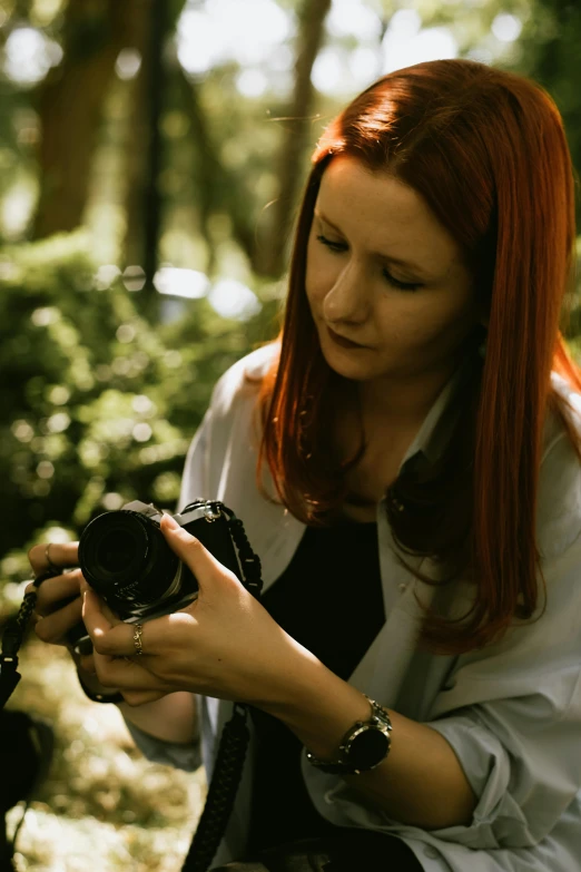 a woman is holding an old camera in her hands