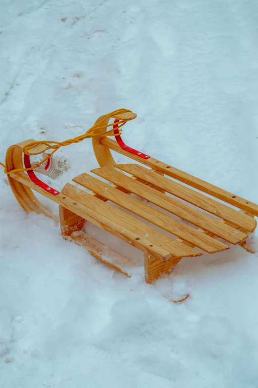 a wooden sled is laying in the snow