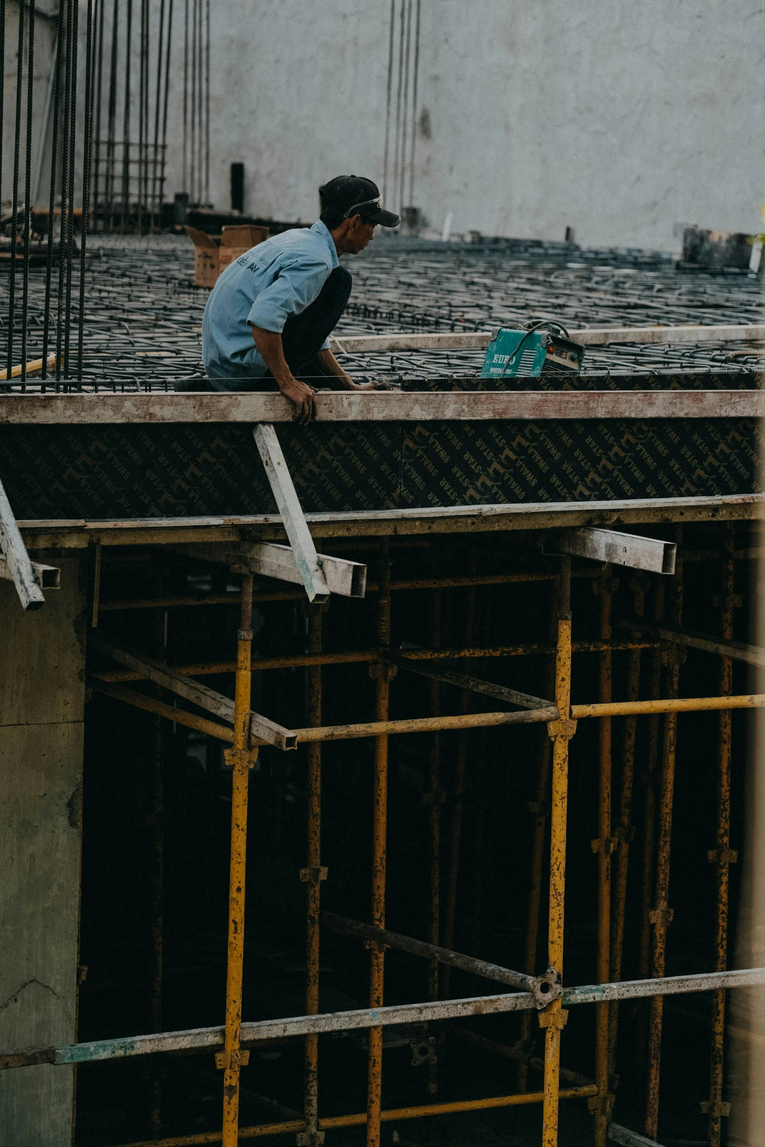 a man in construction gear looking over the top of a building