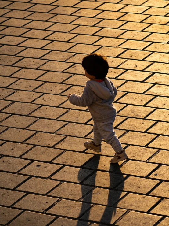 a toddler is standing in the sidewalk