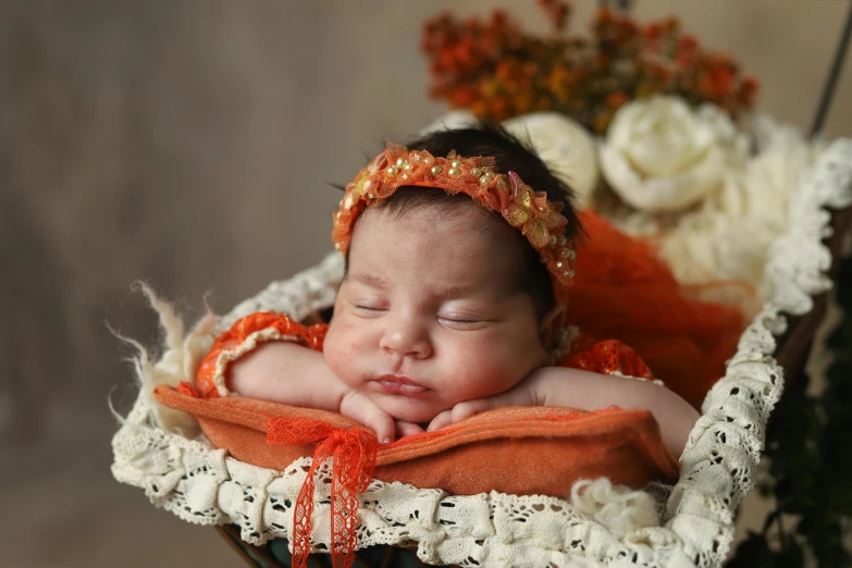 an adorable baby sleeping in a basket with flowers