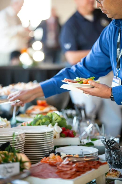 a man standing over some plates with food