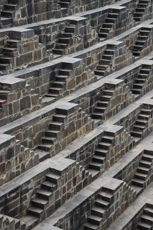 rows of empty stone boxes in front of a stone wall