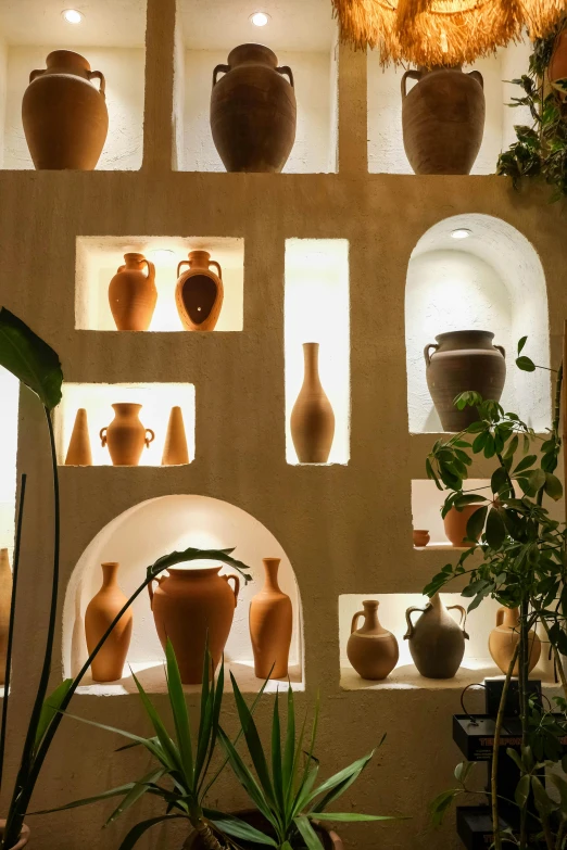many large vases on the wall with windows behind them