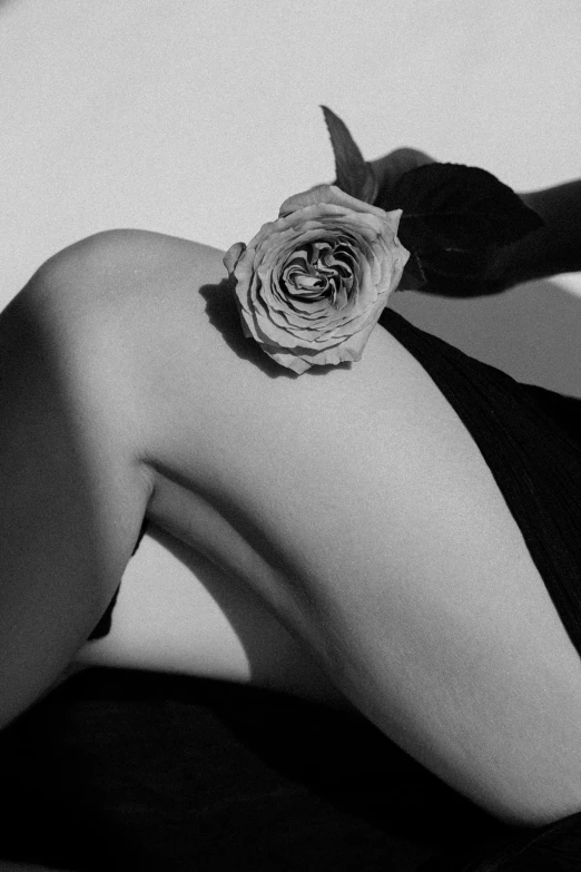 black and white pograph of a woman with a flower on her back