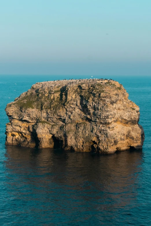 a rock outcropping is seen in the ocean