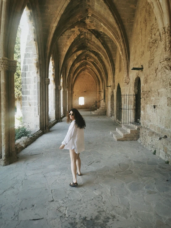 the woman is walking through the stone tunnel