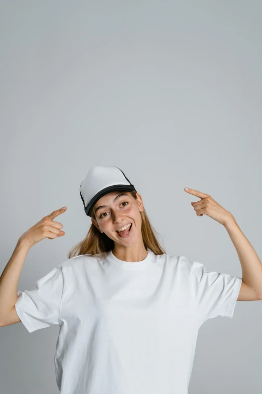 woman with white shirt and white hat holding her hands in the air