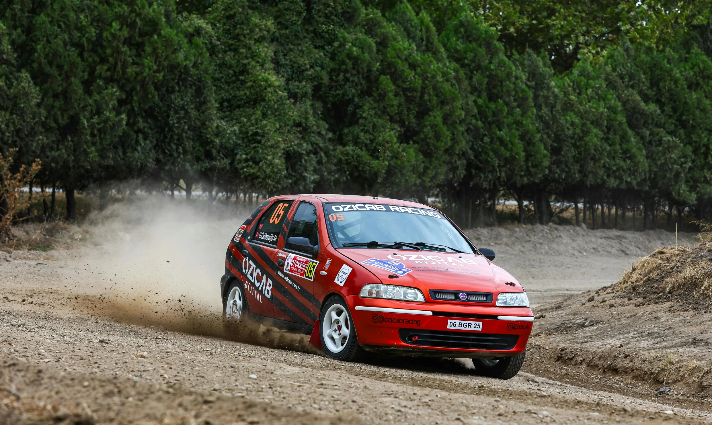 a car driving in the dirt with dirt around it