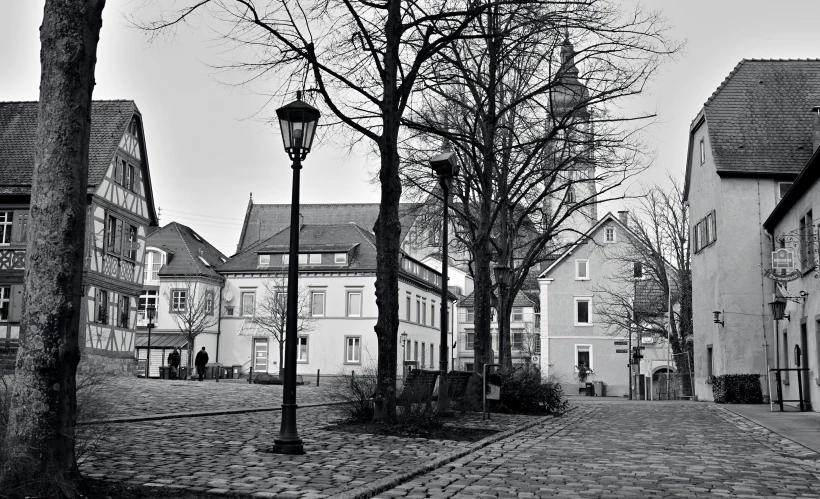 a street lamp on the side of a cobblestone road