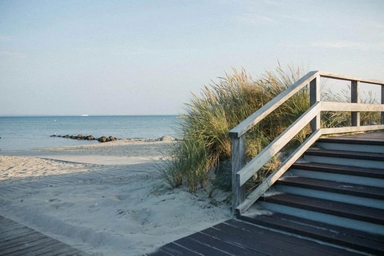 a staircase leading up to the beach and the ocean