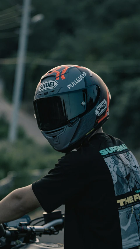 the helmet is on a rider's shoulder while on the motorcycle