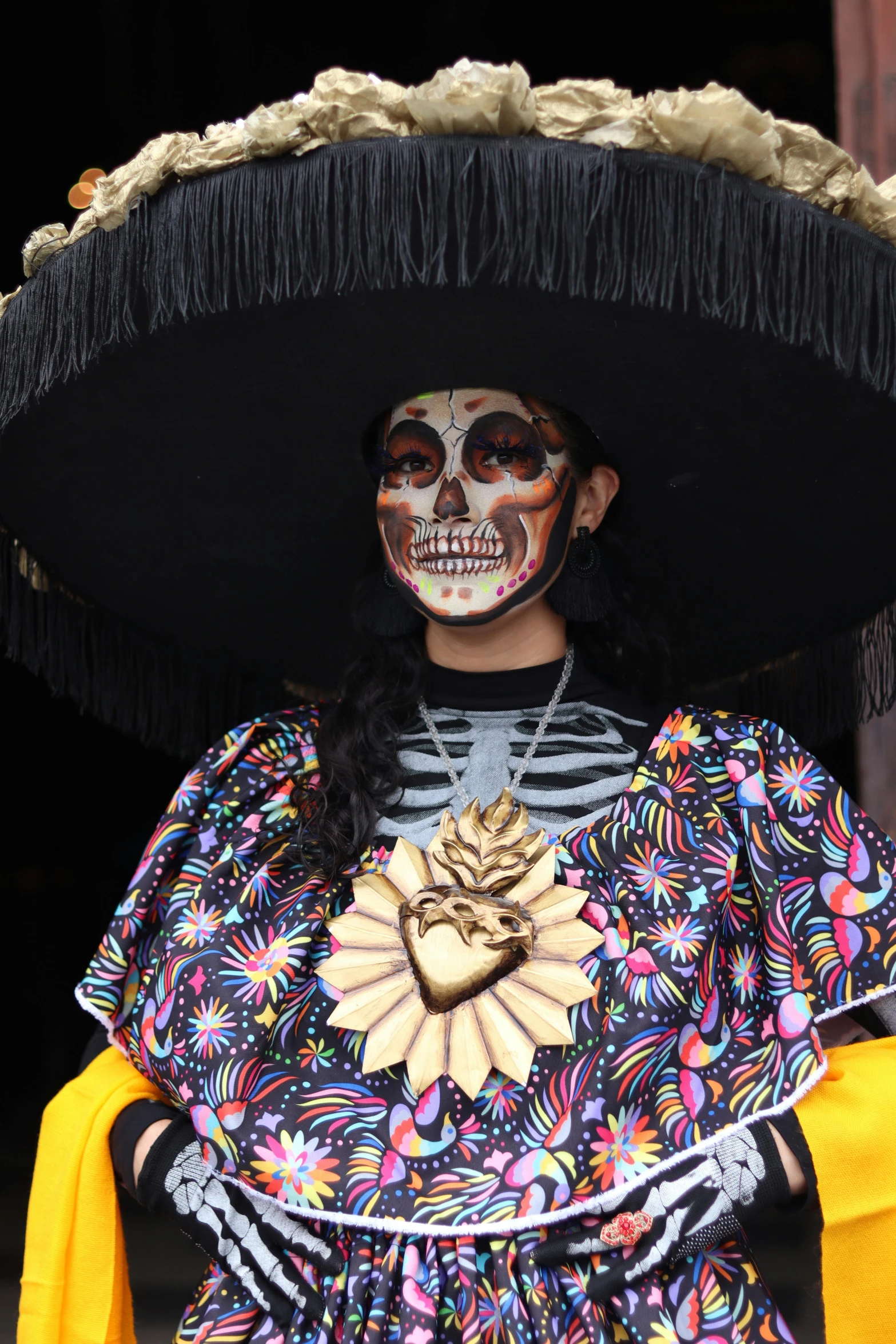 a girl dressed as a skeleton wearing an elaborate hat