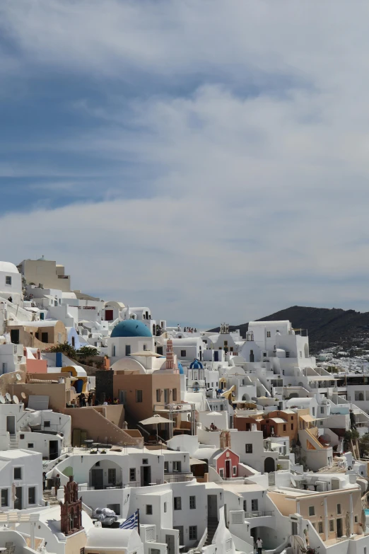 a view of some white buildings and a hill with hills in the background