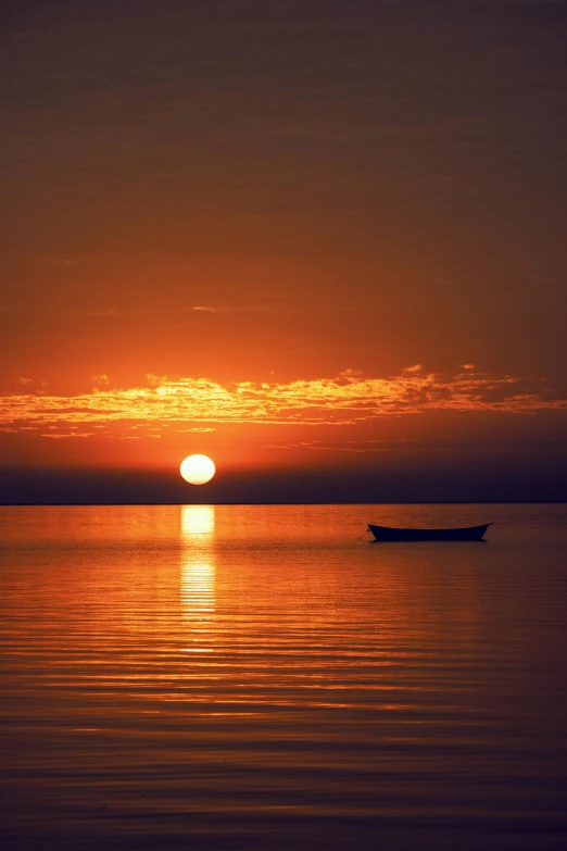an orange sun setting over a body of water