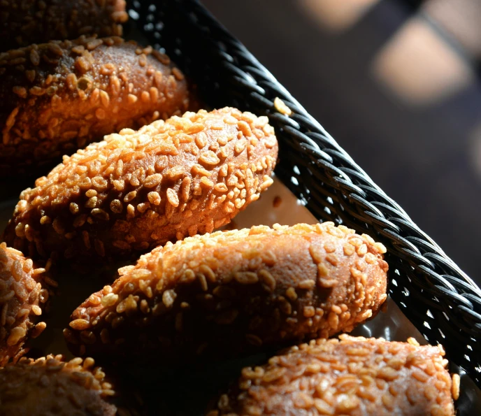 pastries in a black basket lined up on a table