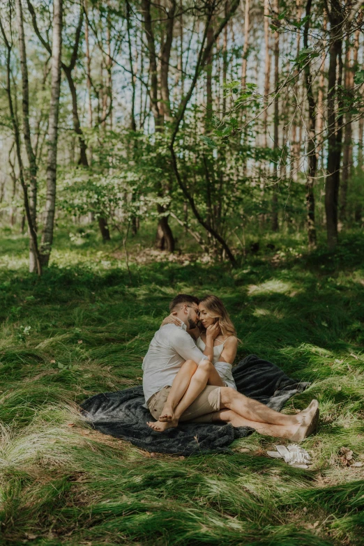 a man and woman emcing on a blanket