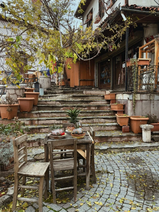 an empty table and two chairs sitting on top of some stone steps