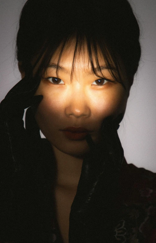 a young lady poses in front of a white background