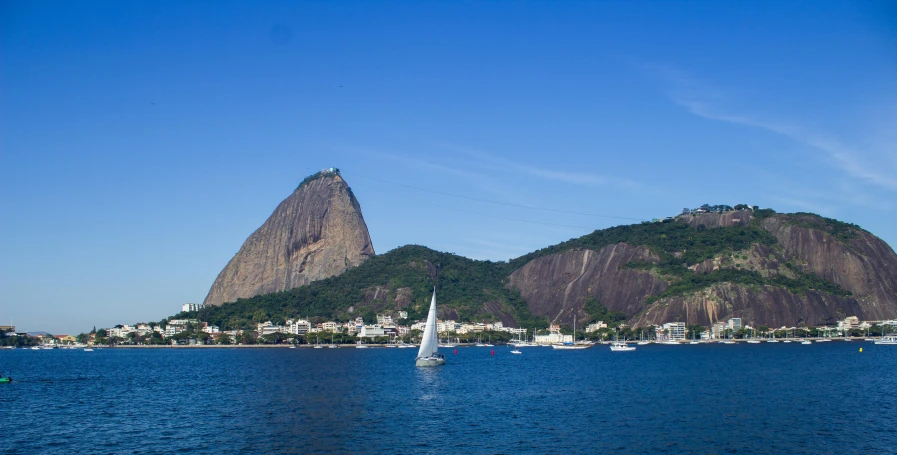 sailboats on water near mountain with sky