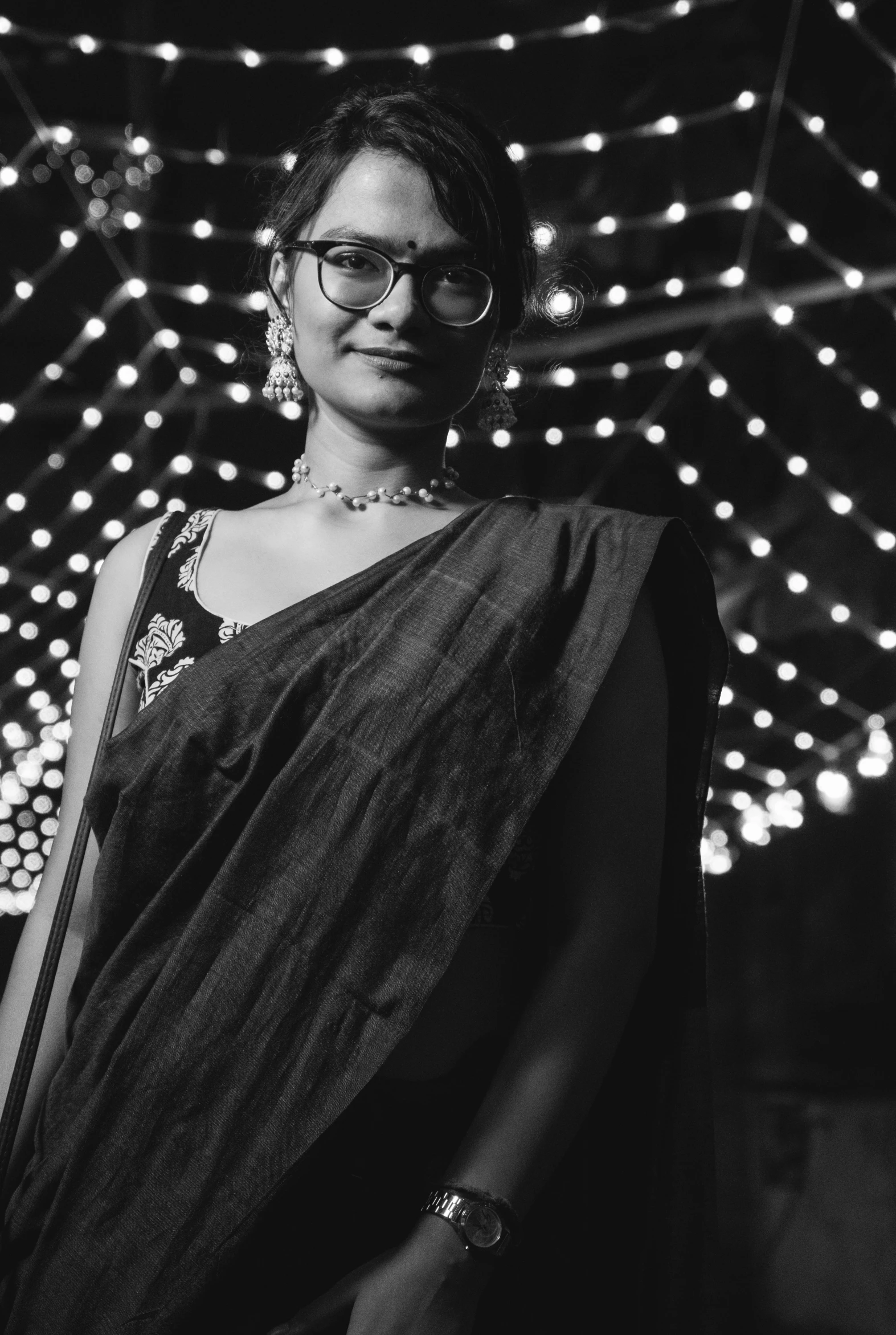 a woman wearing glasses standing with lights