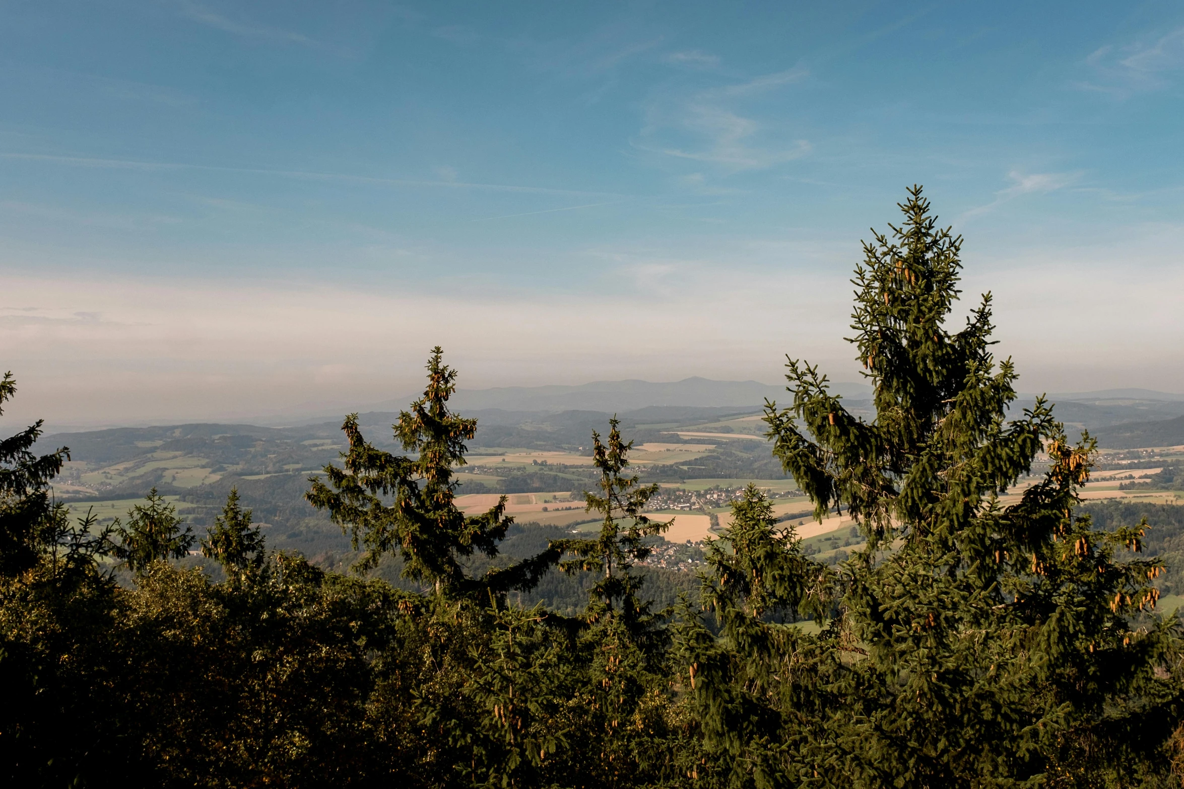 view from top of hill looking over green hills