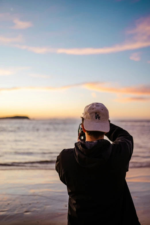 a person wearing a hat and holding a camera takes pictures