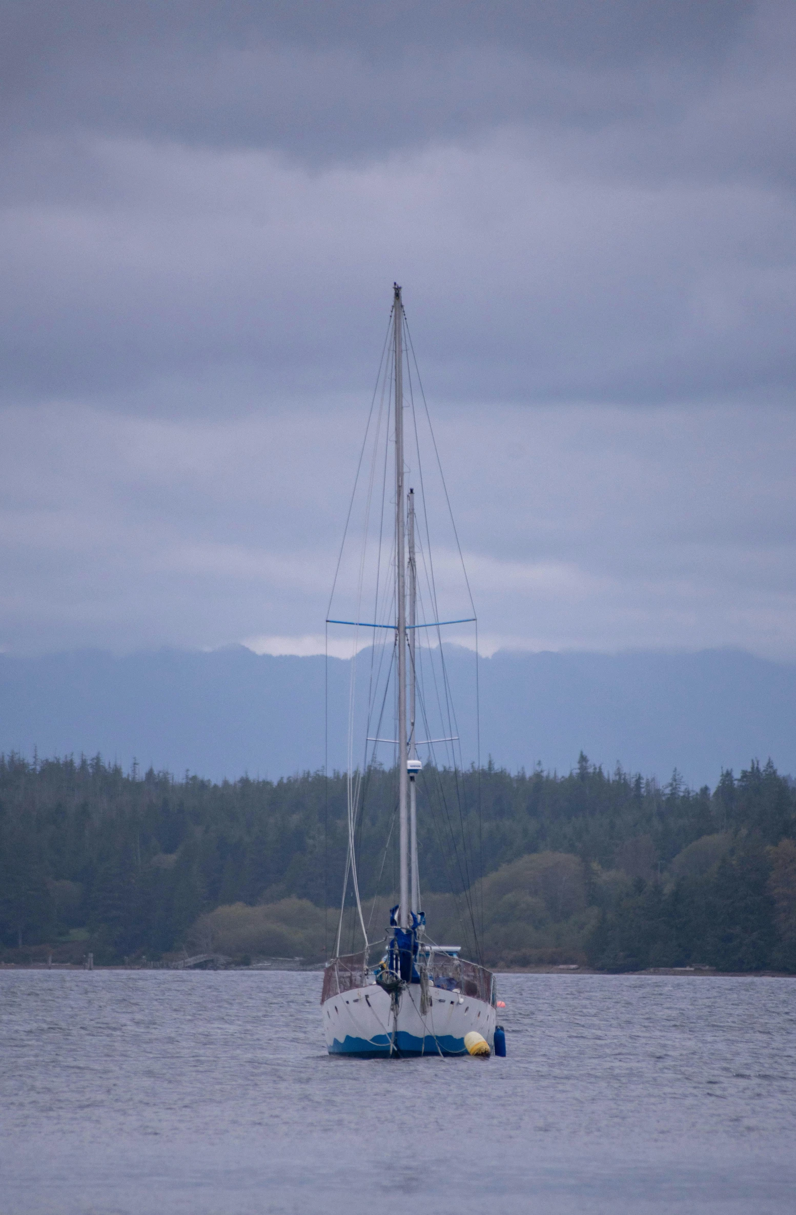 a boat on the water at dusk with cloudy skies