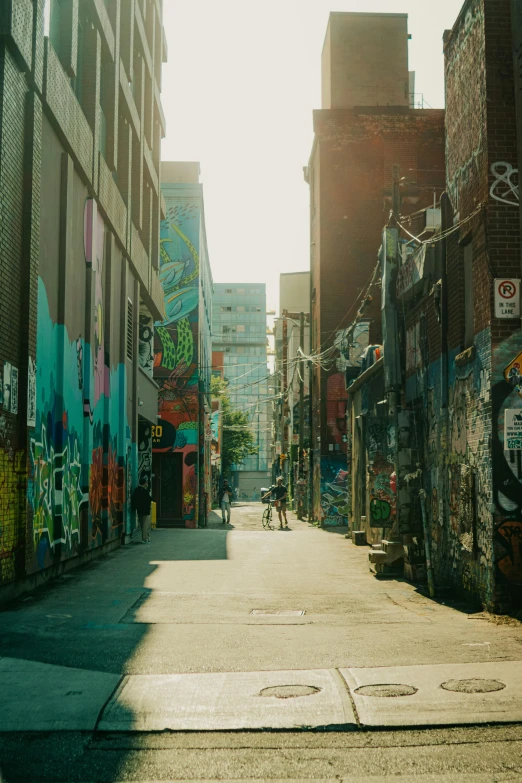 a man is walking down an alleyway covered in graffiti