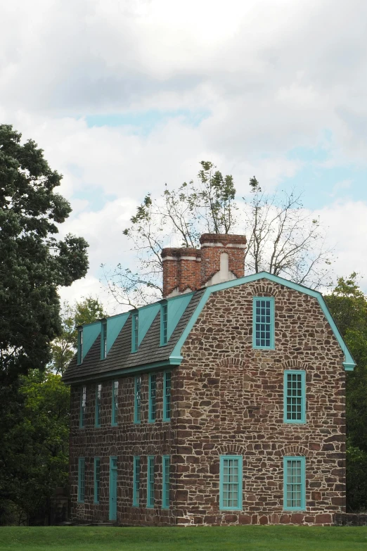 a large brown brick building sitting on top of a lush green field