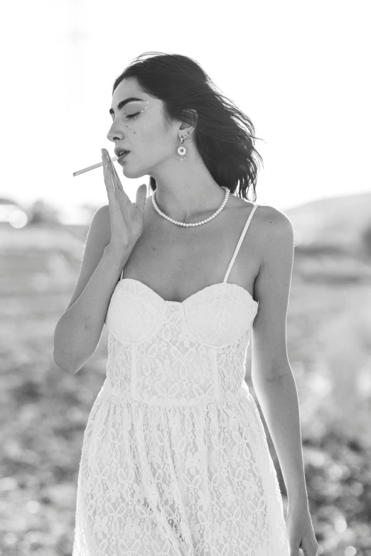 a woman in a lace dress smoking a cigarette