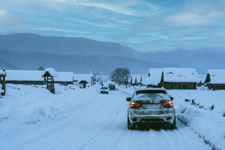 a car that is in the snow by some buildings